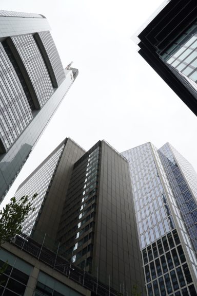 Blick zwischen Frankfurter Hochhäusern, die Linien der Türme verschwinden im Licht.