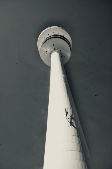 Blick aus der Froschpersepektive auf dem Hamburger Fernsehturm den "Telemichel," minimalistisch in Schwarz-Weiß gehalten.